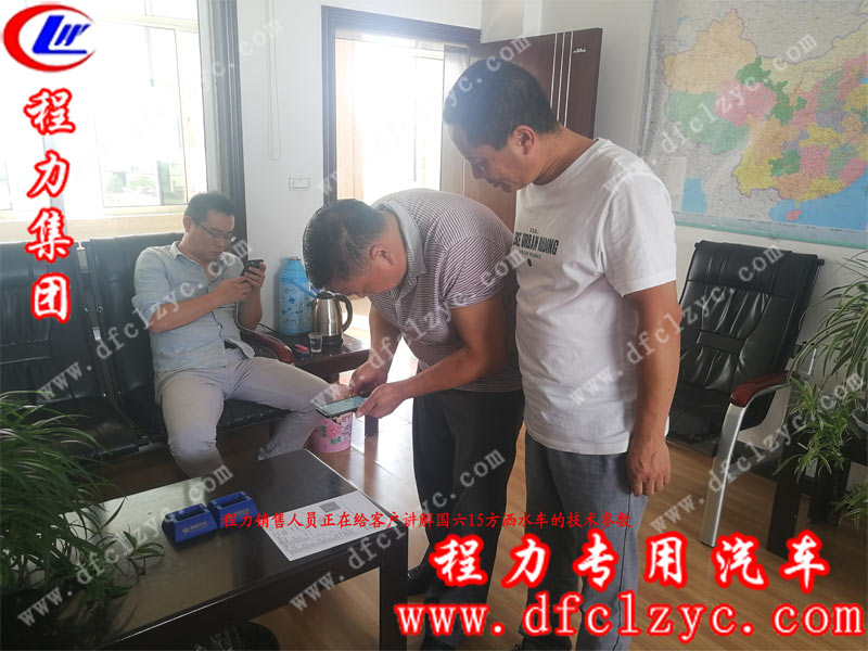 程力銷售人員正在給客戶講解國(guó)六15方灑水車的詳細(xì)參數(shù)